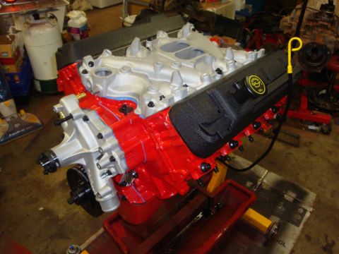 1989 Ford Bronco - Engine assembly with red painted block and silver intake manifold sits on a stand.