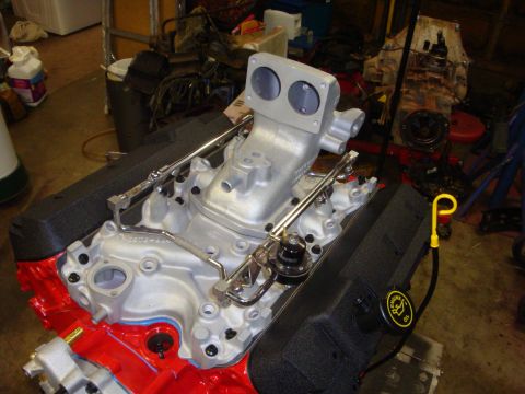 1989 Ford Bronco - Close-up of an engine's intake manifold, dual carburetor openings and fuel system components.