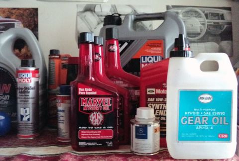 1999 Mercury Grand Marquis - A small Mercedes-Benz part sits among various automotive fluids, including engine oil and gear oil.