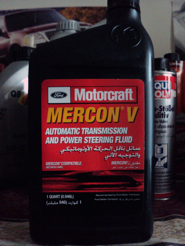 Black bottle of Motorcraft Mercon V fluid with red label showing Arabic text