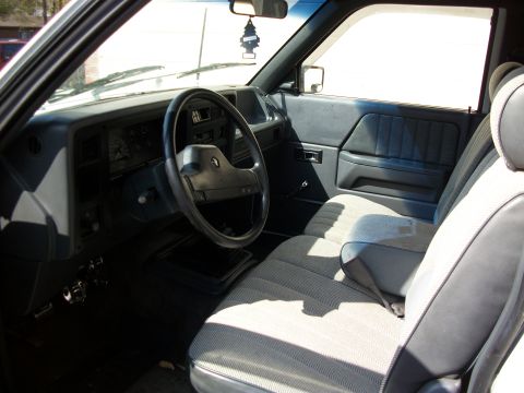 1994 Ford Explorer - The interior of a truck shows the dashboard, steering wheel, and passenger seat with fabric upholstery.