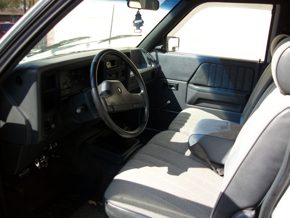 Gray cloth bench seat and blue-gray dash interior of an older Ford truck