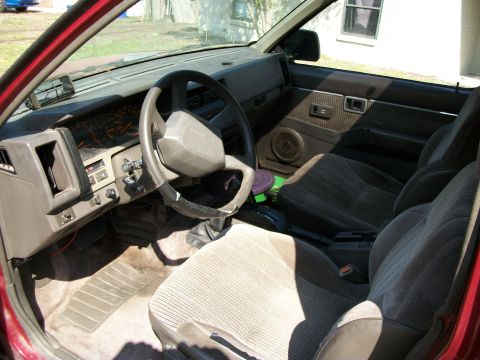 1994 Ford Explorer - The interior of a car is shown, cloth seats, a steering wheel, and dashboard instrumentation.