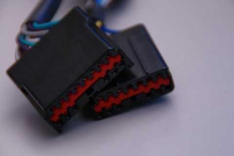 2003 Ford Taurus - Close-up of two automotive electrical connectors with red locking mechanisms and visible wiring.