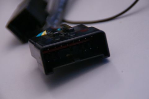 2003 Ford Taurus - Close-up of a black electrical connector with multiple pins and some colored wire insulation visible.