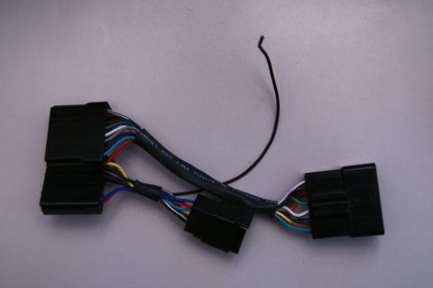 2003 Ford Taurus - This wiring harness adapter features multiple colored wires connecting two black plastic connectors.