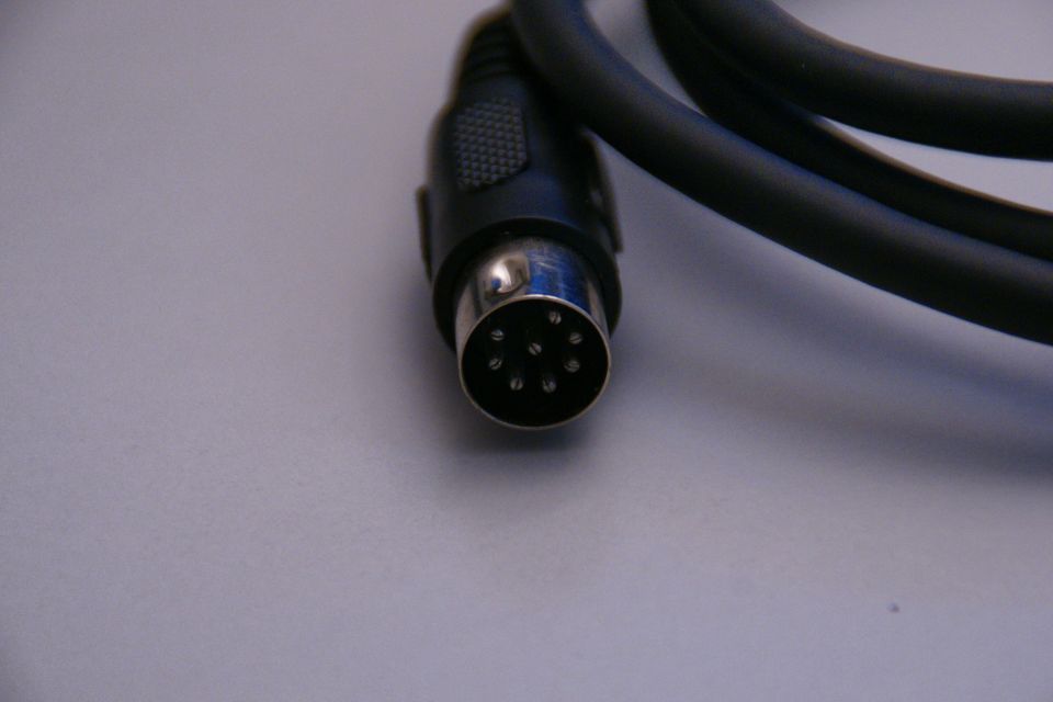 Close-up of a black audio connector cable with a silver 6-pin DIN plug