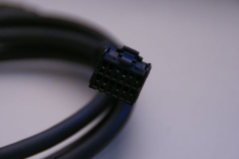 2003 Ford Taurus - A black wiring harness connector with a blue locking tab is shown against a light background.