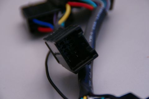 2003 Ford Taurus - Close-up of a black plastic wiring harness connector with visible colored wires and text on the cable.