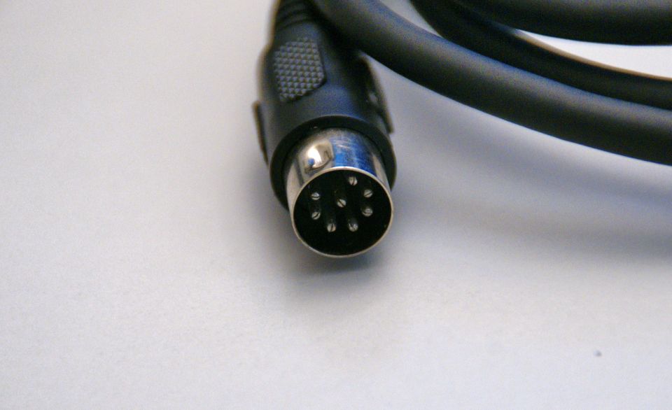 Close-up of a black audio cable with a silver 6-pin DIN connector