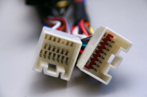 2003 Ford Taurus - Close-up of two automotive wiring harness connectors with visible pins and wires.