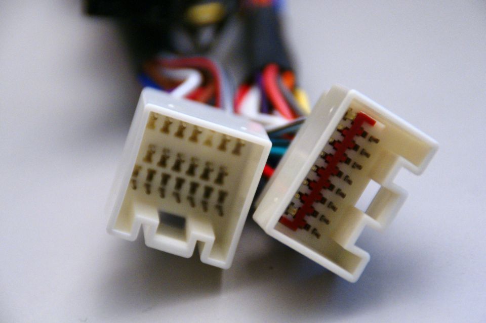 Two white plastic wiring harness connectors with multiple wires