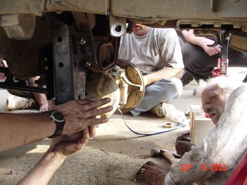 1989 Ford Bronco - Mechanics work on the suspension of a vehicle, with a date stamp of September 8, 2003 visible.
