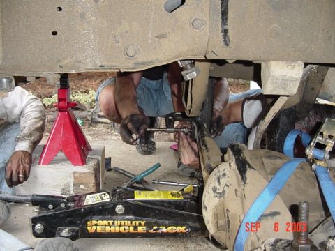 1989 Ford Bronco - Vehicle maintenance in progress with multiple tools and supports visible under the chassis.