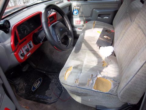 1989 Ford F-150 - The interior of this 1989 Ford F-150 shows significant wear on the driver's seat and dashboard modifications.