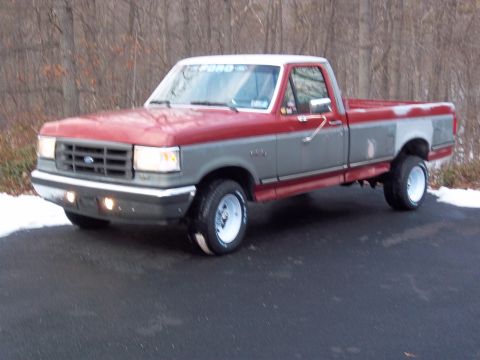 1989 Ford F-150 - This pickup truck has a two-tone paint scheme with red on top and gray on the lower half.