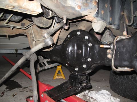 1995 Ford Bronco - Underneath view of a vehicle's rear axle and suspension, with mechanical components and lifting equipment.