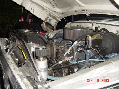 1989 Ford Bronco - Engine bay with aftermarket modifications, including a chrome air cleaner and oil catch can.