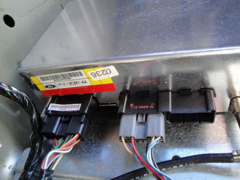 2003 Ford Taurus - Close-up of a Ford electronic control module, showing connected wiring harnesses and part number.