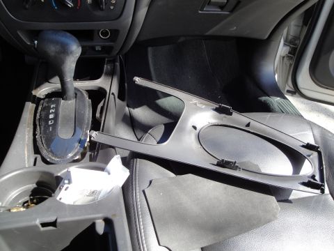 2003 Ford Taurus - The center console of a car shows a gear shifter and a removed trim piece, suggesting a repair or modification.