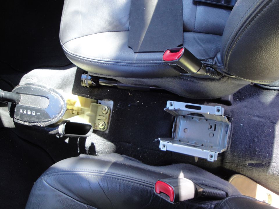 Car interior showing gear shifter and open ashtray