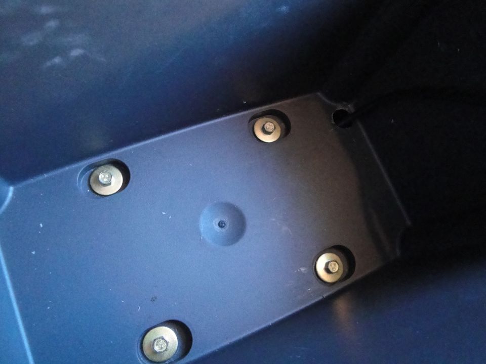 Interior plastic part with four visible bolts and a central circular indentation