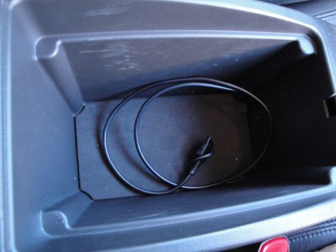 2003 Ford Taurus - Center console storage bin contains a black cable with a USB connector.