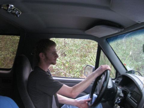 1994 Ford Bronco - A man drives a vehicle through a wooded area, with the interior and dashboard visible.