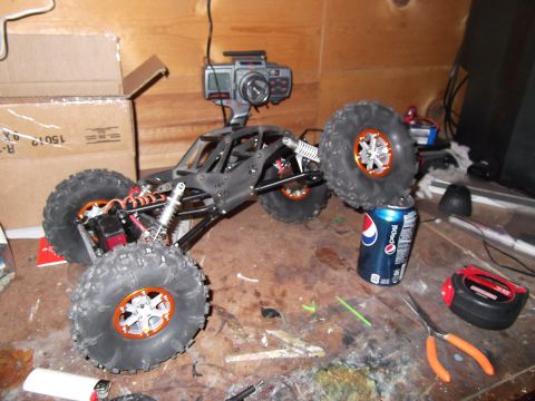 1989 Ford Bronco - A remote-controlled rock crawler sits on a workbench next to tools and a Pepsi can.