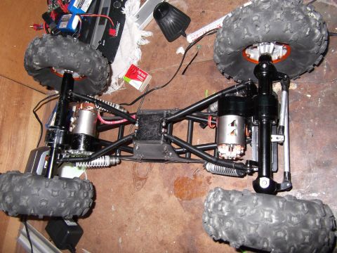 1989 Ford Bronco - Chassis of a remote control rock crawler, showing motors and suspension components.
