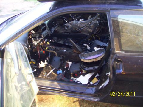 1995 Ford Probe - The interior of a dark car is heavily dismantled, with the dashboard removed and wires exposed.
