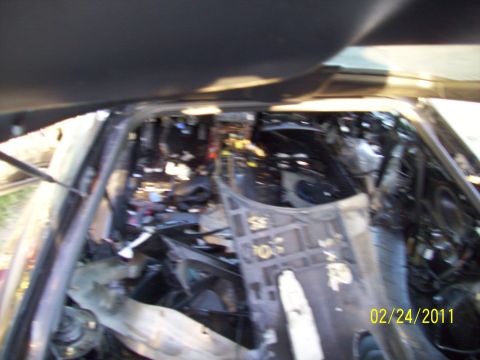 1995 Ford Probe - The interior of a car shows significant damage and disarray, with exposed components and wiring visible. A date stamp indicates the photo w…