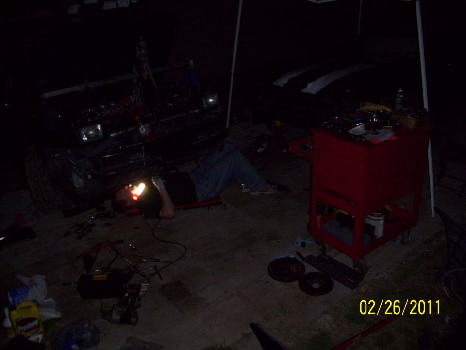 1995 Ford Probe front end with a person lying underneath working on it