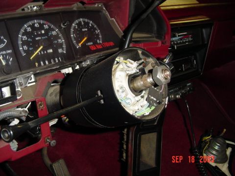 1989 Ford Bronco - Disassembled steering column and dashboard of a 1989 Ford Bronco, with visible gauges and radio.
