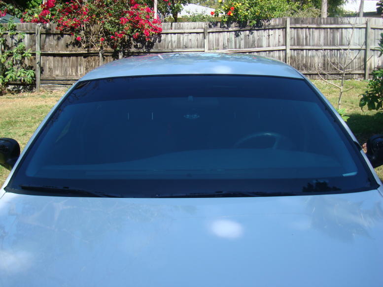 Front windshield with dark tint and a glimpse of the steering wheel