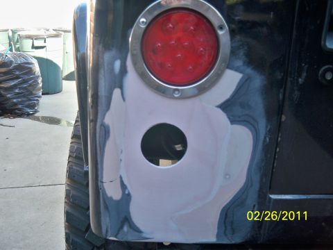 1992 Jeep Wrangler - Bodywork is being done on the rear corner of a Jeep, with a tail light removed and a new hole cut.