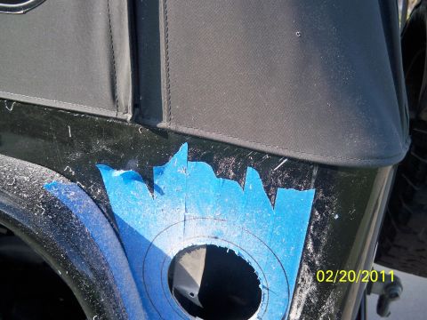 1992 Jeep Wrangler - A black Jeep fender shows blue tape and cut marks, indicating a modification is in progress.