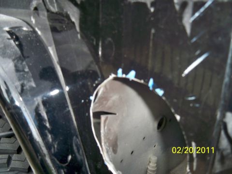 1992 Jeep Wrangler - This photo shows a modified vehicle fender well, possibly for filler relocation, with visible cutouts and blue paint.