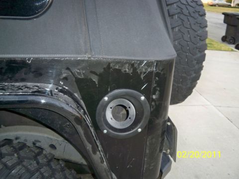 1992 Jeep Wrangler - Rear view of a black Jeep Wrangler showing body damage and a modified fuel filler location.