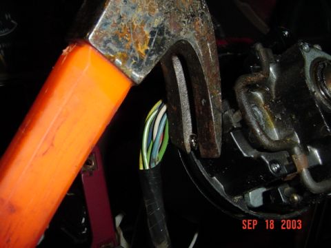 1989 Ford Bronco - A tool is used to manipulate the ignition wiring harness of a vehicle.