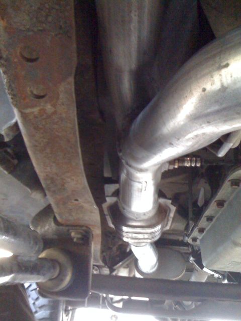1990 Ford Bronco - Underside view of a vehicle's exhaust system, showing the catalytic converter and piping.