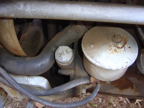 1986 Ford Bronco - Close-up view of engine components, including an oil cap and filter housing, with visible hoses and pipes.