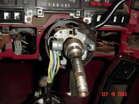 1989 Ford Bronco - The steering column is disassembled, revealing wiring and mechanical components within the vehicle's dashboard.
