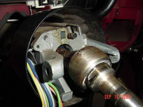 1989 Ford Bronco - Close-up of a vehicle's steering column ignition switch assembly, showing internal mechanical components and wiring.