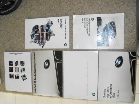 1994 Ford Bronco - A collection of BMW documentation, including owner's manuals and a 1994 accessories catalog, is displayed.