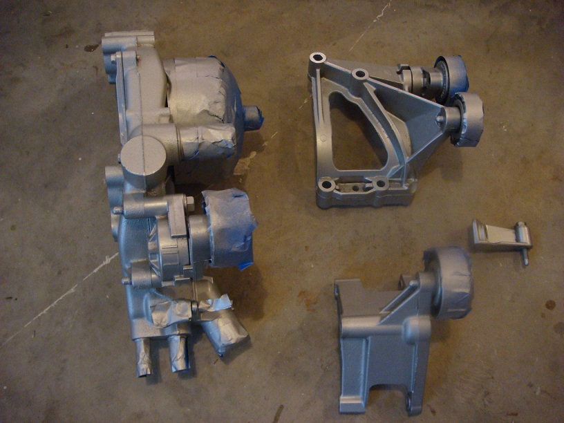 Engine components, possibly for an LS swap, taped and painted silver