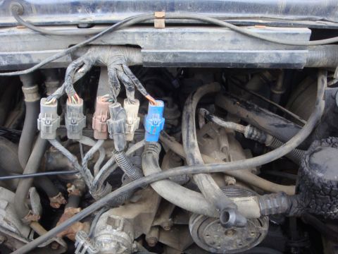 1989 Ford Bronco - Close-up view of the engine bay, showing a complex wiring harness and various hoses.