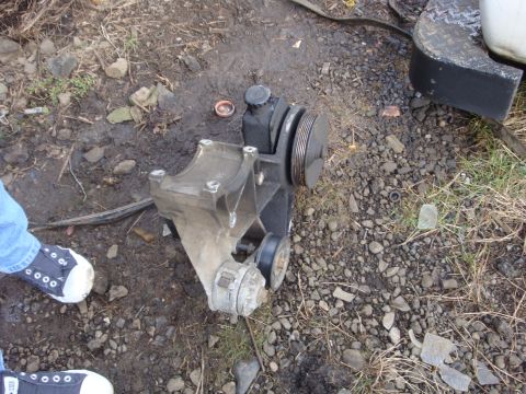 1989 Ford Bronco - Power steering pump assembly with pulley and bracket is shown on the ground.