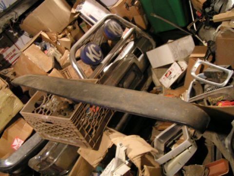 1979 Ford Bronco - A collection of assorted vehicle parts and storage boxes are piled together in a cluttered space.