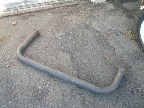 1979 Ford Bronco - Exhaust pipe part shown on asphalt with a tire visible on the right.